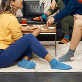 People sitting on a couch wearing colorful socks with a focus on their feet. thumbnail