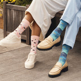 Two women sitting on a bench wearing HOTSOX novelty socks. thumbnail