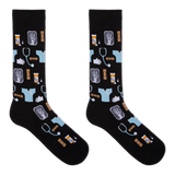 A pair of black crew socks with a medical-themed pattern featuring light blue scrubs, stethoscopes, X-ray images, pills, and hands, displayed against a solid white background. thumbnail