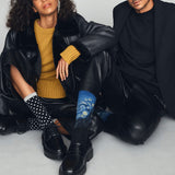 Two people sitting side by side wearing stylish outfits with socks.