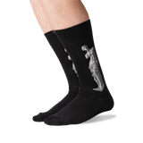 Black crew socks worn on a person's legs, featuring a light gray classical statue graphic printed on the side. thumbnail