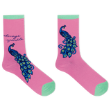 A pair of pink crew socks with mint green toes and heels, featuring a large blue and green peacock design and the text 'always sparkle' on one sock, shown on a white background.
