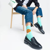 Person wearing light blue socks with a donut design, sitting on a chair. thumbnail