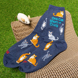 Blue socks with cat designs and text on a woven chair with a grass background