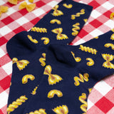 Navy blue socks with yellow pasta pattern on a red and white checkered tablecloth