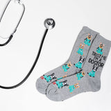 Gray socks with dog illustrations and text, paired with a stethoscope on a light gray background thumbnail