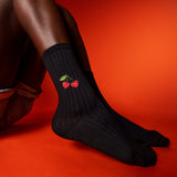 Black socks with red cherry design on a red background thumbnail