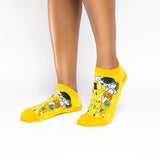 A pair of low-cut yellow socks with a Gustav Klimt 'The Kiss' art print, shown on a model's feet against a white background. thumbnail