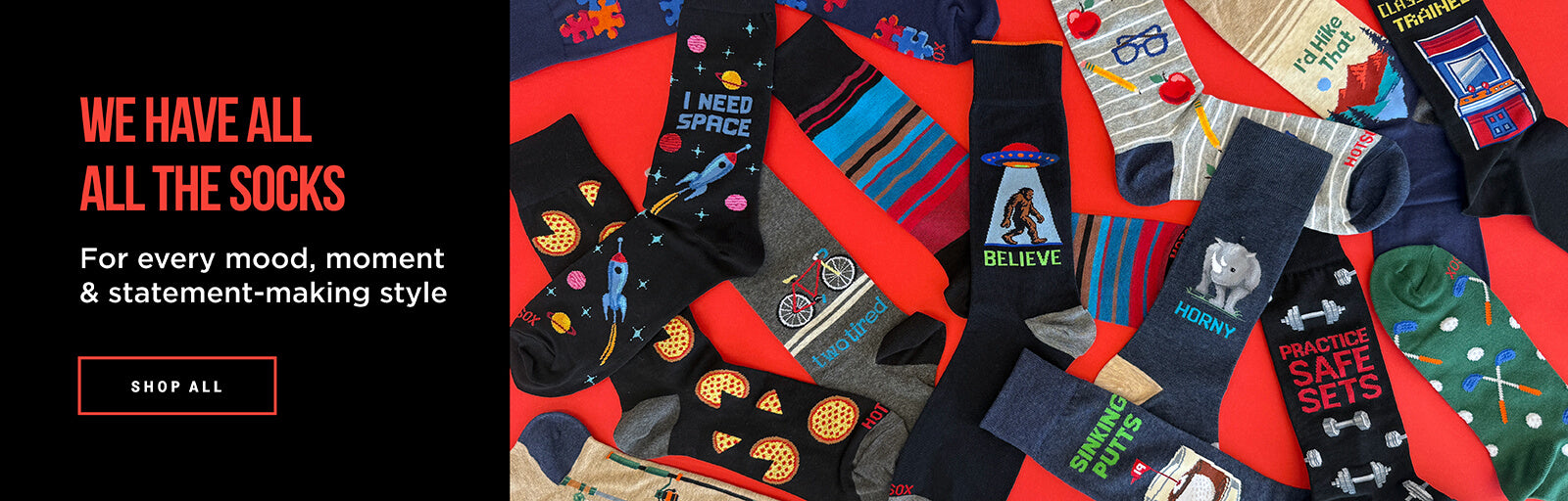 A promotional banner showing a large assortment of colorful novelty socks laid out on a bright red background, with bold text on the left reading 'WE HAVE ALL THE SOCKS' and 'For every mood, moment & statement-making style.'.