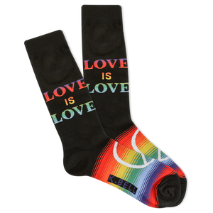 A pair of men's crew socks with the phrase 'love is love' printed in colorful letters on a black background, and a rainbow stripe design at the cuff.