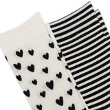 Two pairs of knit socks shown on a white background: one pair is off-white with scattered black heart motifs, and the other pair is black and white striped. thumbnail
