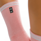 Pink ankle support brace with 'K.B' logo on a white background