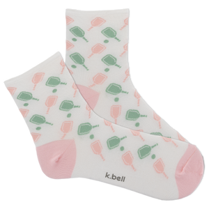 Pair of socks with a pattern of green and pink shapes on a white background, featuring the brand 'k.bell'.