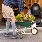 Person pushing a wheelbarrow with plants in a garage setting thumbnail