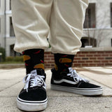 Child wearing sneakers, cream sweats and HOTSOX socks with taco and pepper designs.