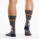 Gray socks with whiskey label design worn by a person on a white background