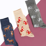 Three pairs of socks with animal patterns on a geometric background thumbnail