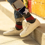 Person wearing patriotic-themed socks with a star design, standing on a concrete surface. thumbnail