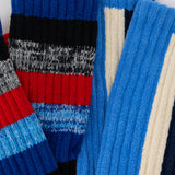 Close-up of a colorful striped sweater with blue, red, and gray patterns. thumbnail