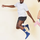 Person wearing blue socks with a design that says "Sun day Fun day" on a beige background