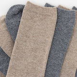 Stack of beige and gray socks on a white background